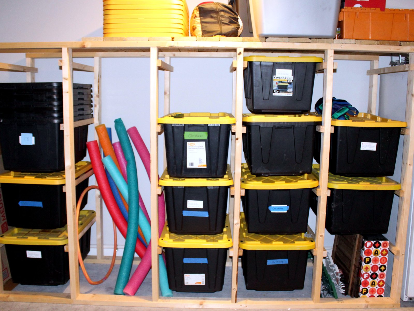 Custom wood-frame garage storage shelving unit with labeled bins