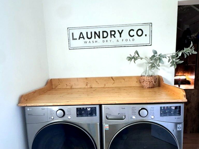 Floating wood shelf built above a stacked washer and dryer